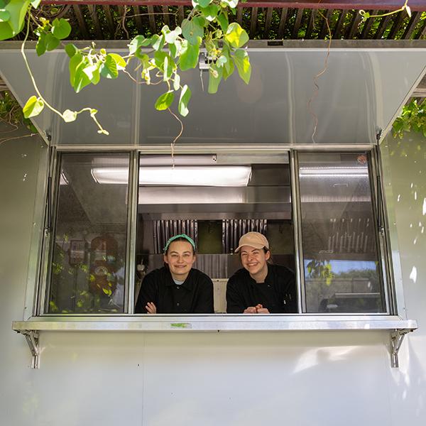 Two staff looking out ordering window of Farm Cart