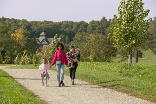 Two famlies walking along trails in front of the Farm Barn